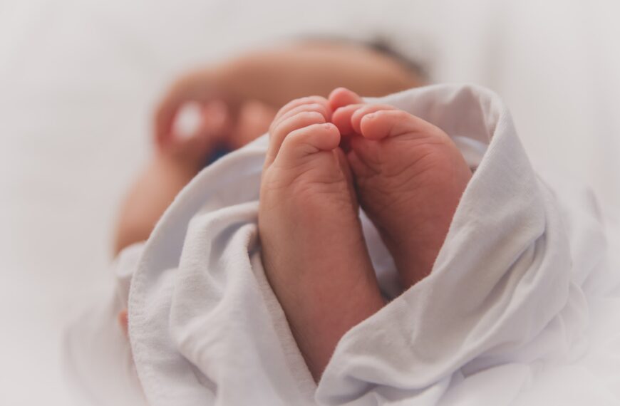 baby covered with white blanket