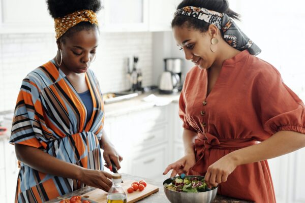 Two friends are preparing food for Friendsgiving.