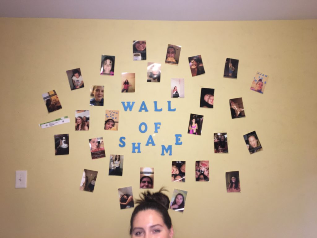 roommate under a wall covered with memorable pictures from final year of college