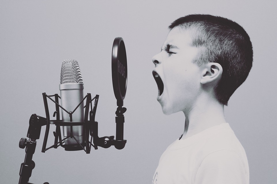 Young boy singing into microphone. change your mind