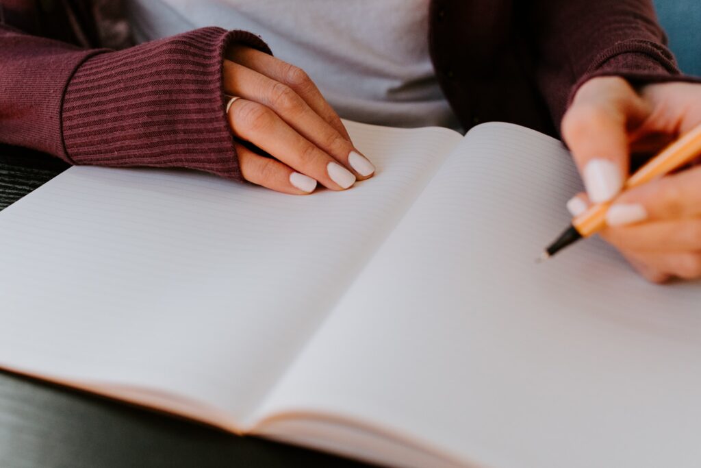 person writing on white paper