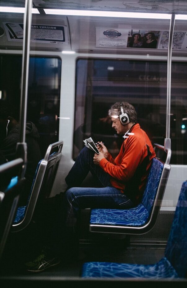 man sitting inside train while reading